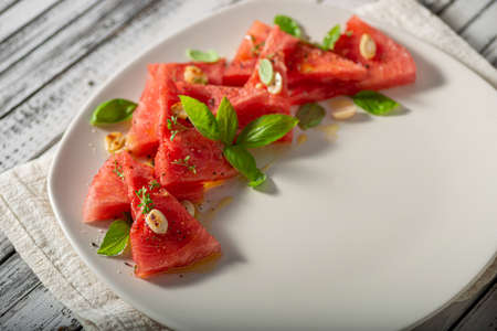 Bio watermelon with nuts, basil and olive oilの写真素材