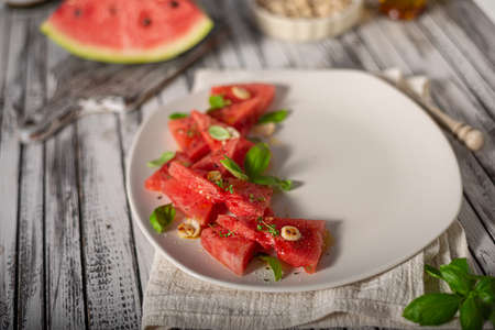 Bio watermelon with nuts, basil and olive oilの写真素材