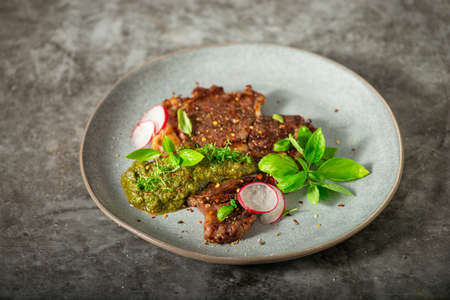 Delicious rib eye steak with pesto and garnishの写真素材