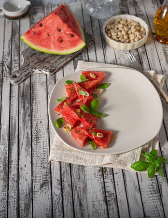 Bio watermelon with nuts, basil and olive oilの写真素材