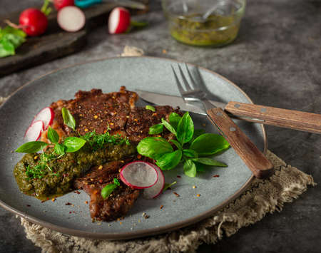 Delicious rib eye steak with pesto and garnishの写真素材