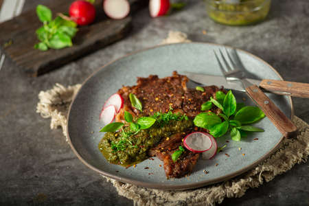 Delicious rib eye steak with pesto and garnishの写真素材