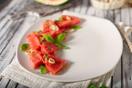 Bio watermelon with nuts, basil and olive oilの写真素材