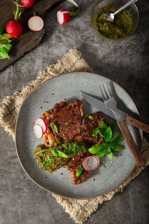 Delicious rib eye steak with pesto and garnishの写真素材