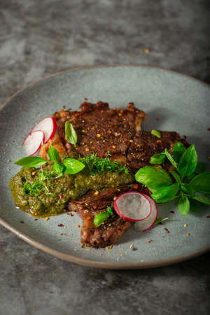 Delicious rib eye steak with pesto and garnishの写真素材