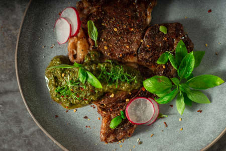 Delicious rib eye steak with pesto and garnishの写真素材