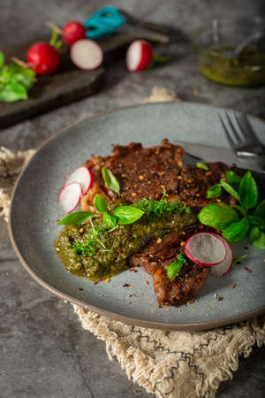 Delicious rib eye steak with pesto and garnishの写真素材