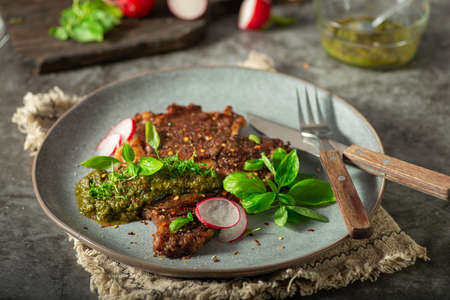 Delicious rib eye steak with pesto and garnishの写真素材