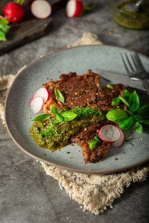 Delicious rib eye steak with pesto and garnishの写真素材