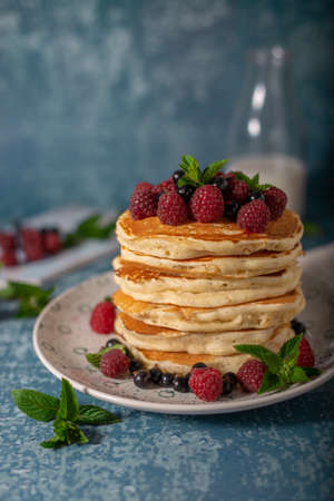 Delicious fluffy pancakes with berries and maple syrupの写真素材