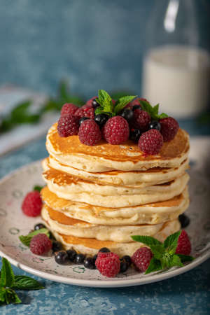 Delicious fluffy pancakes with berries and maple syrupの写真素材