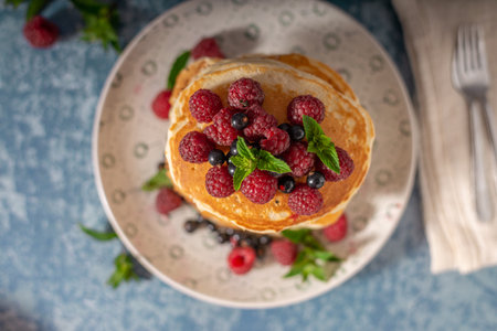 Delicious fluffy pancakes with berries and maple syrupの写真素材