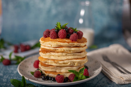 Delicious fluffy pancakes with berries and maple syrupの写真素材
