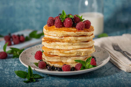 Delicious fluffy pancakes with berries and maple syrupの写真素材