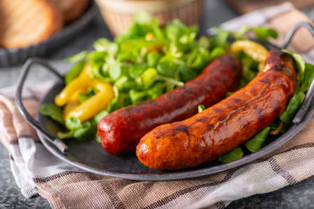 Delicious and spicy sausages on grill with breadの写真素材