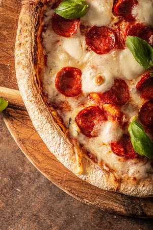 Delicous pizza with hot salami, parmesan and fresh basilの写真素材
