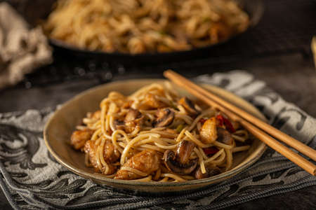 Delicious noodles with crispy chicken and mushroomsの写真素材