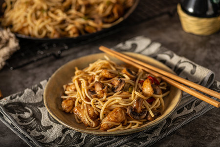 Delicious noodles with crispy chicken and mushroomsの写真素材