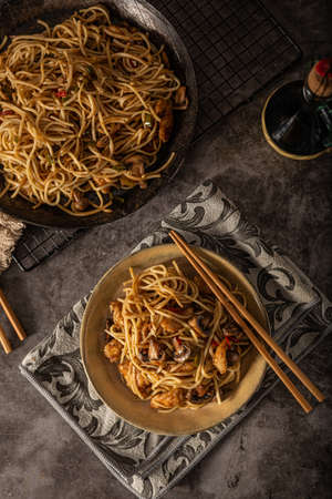 Delicious noodles with crispy chicken and mushroomsの写真素材
