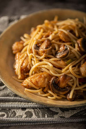 Delicious noodles with crispy chicken and mushroomsの写真素材