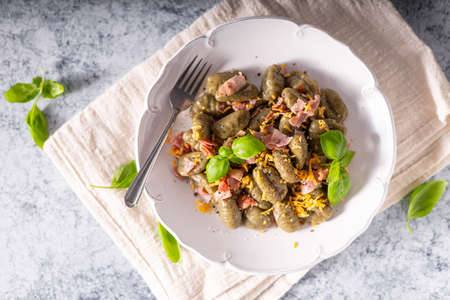 Homemade spinach gnocchi with ham and cheddar cheeseの写真素材