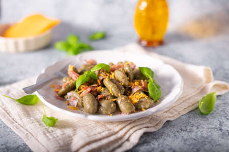Homemade spinach gnocchi with ham and cheddar cheeseの写真素材