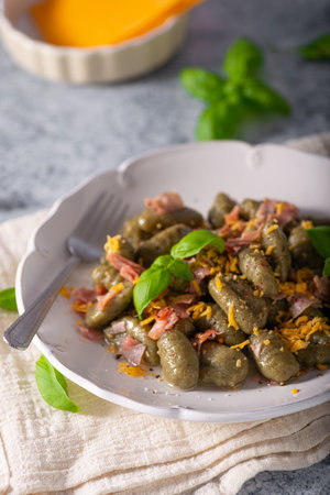 Homemade spinach gnocchi with ham and cheddar cheeseの写真素材