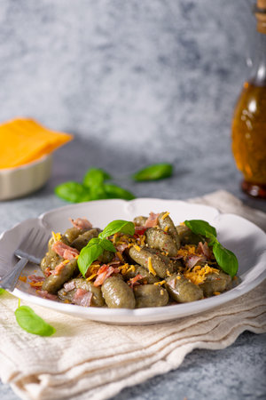 Homemade spinach gnocchi with ham and cheddar cheeseの写真素材