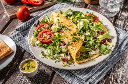 Delicious eggs omelette with salad and vegetablesの写真素材