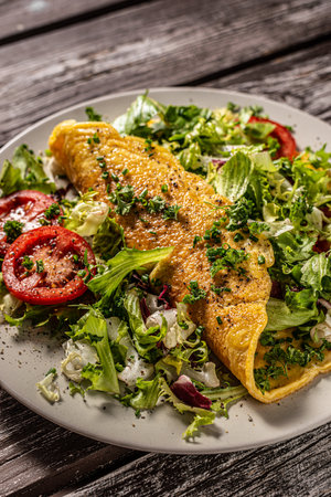 Delicious eggs omelette with salad and vegetablesの写真素材