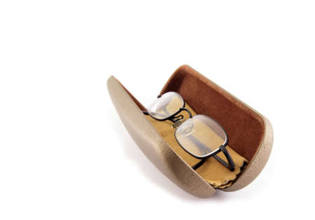 Pair of black rimmed metal spectacles in glasses case with Chamois leather cleaning cloth isolated on whiteの写真素材
