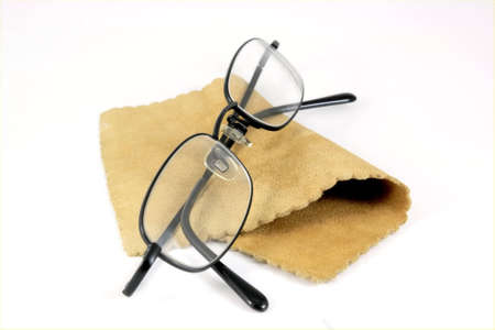 Pair of black rimmed metal spectacles in glasses case with Chamois leather cleaning cloth isolated on whiteの写真素材