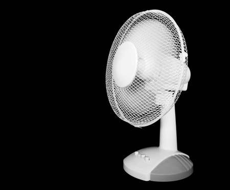 Rotating white desk fan islolated on blackの写真素材
