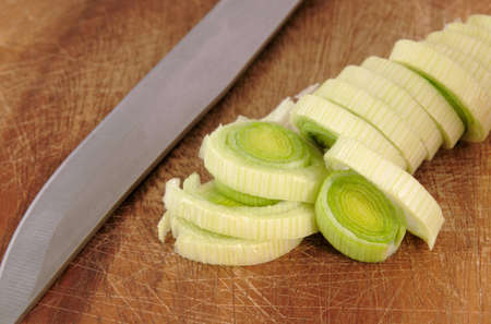 Freshly chopped leek on a chopping board with knifeの写真素材