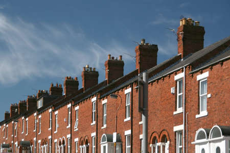 A row of terraced houses with beautiful whispy cloud backgroundの写真素材