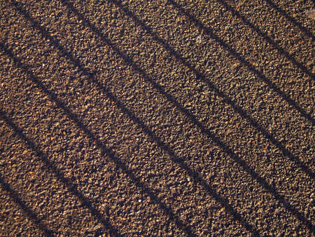 Diagonal shadow of railings on pavement tarmacの写真素材