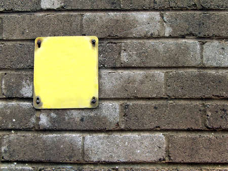 blank yellow notice board on wall for addition of textの写真素材