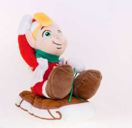 A stuffed cuddly toy gnome in santa claus outfit on sledge