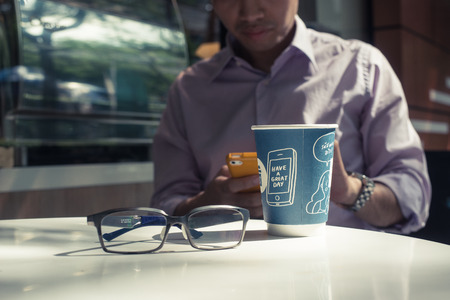 Businessman working with smart phone in coffee cafe.の写真素材