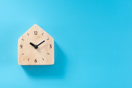 Wooden clock on blue background.の写真素材