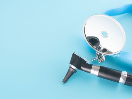 Otoscope with reflector mirror on blue background in health care concept.の写真素材