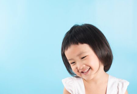Cute asian girls show happiness. In various postures on a blue background with copy space.