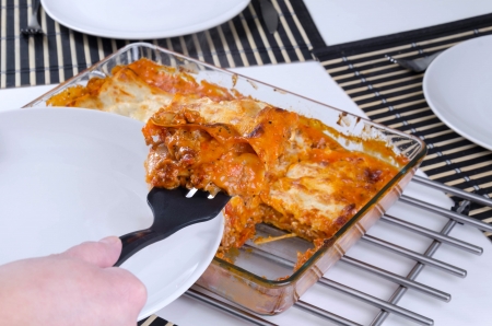 Lasagna slice sharing on plateの写真素材