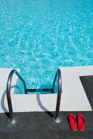 	Red flip flops near tropical poolの写真素材