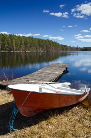 Red boat on spring lake coastの写真素材