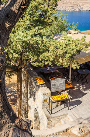 Greek small restaurant with juicy orange in frontの写真素材