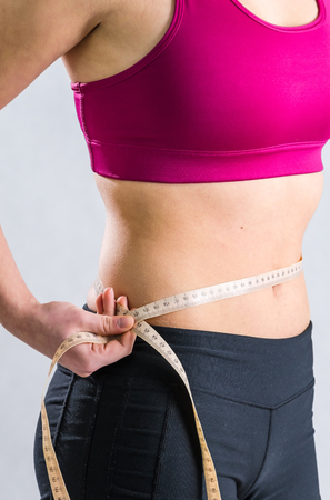 Slim girl's body isolated on grey backgroundの写真素材