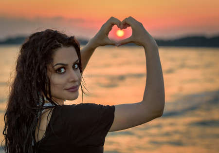 Beautiful brunette in sea sunset expressionの写真素材