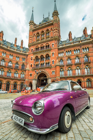 LONDON, UK - 15 JULY, 2016: A classic, purple Nissan Figaro car in front of The St Pancras Hotel in London, UK. Nissan Figaro is a two-door 2+2 retro-styled Nissan car model from 1991.のeditorial素材