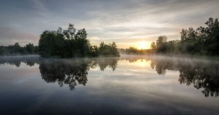Summer sunrise over Swedish lakeの写真素材